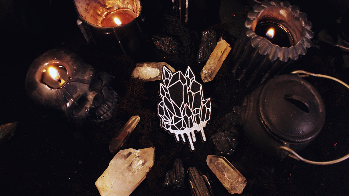 Iron on embroidered patch of a black crystal cluster with white outlines and dripping white at the bottom. Original design by GRRRL Spells.