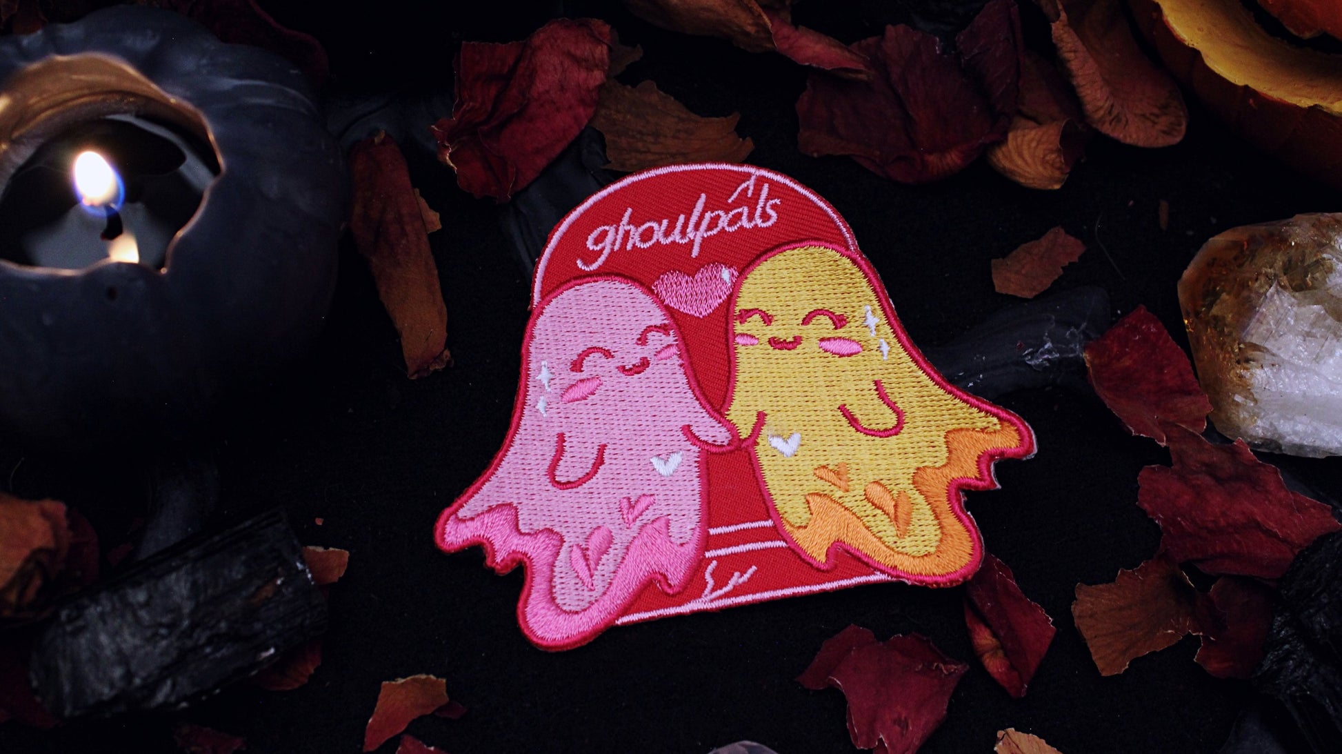 Ghoulpals Lesbian Patch - Iron on  embroidered patch of two cute and smiling ghosts holding hands in front a tombstone that says "ghoulpals" with a heart in between them, in the colours of the lesbian flag which is orange, pink, and magenta. Original design by GRRRL Spells. 