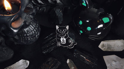 Black Cat Boba Pin - Silver plated enamel pin of a cute black cat sitting upright with a little smirk on its face while sipping on a cup of bubble tea/boba with moon and stars in it. Original design by GRRRL Spells.