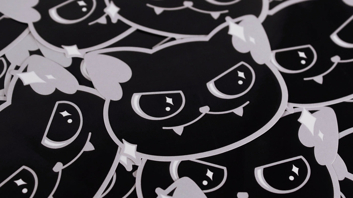 Vinyl stickers of a cute black cat with a little smirk and sparkles around its face. Original design by GRRRL Spells.