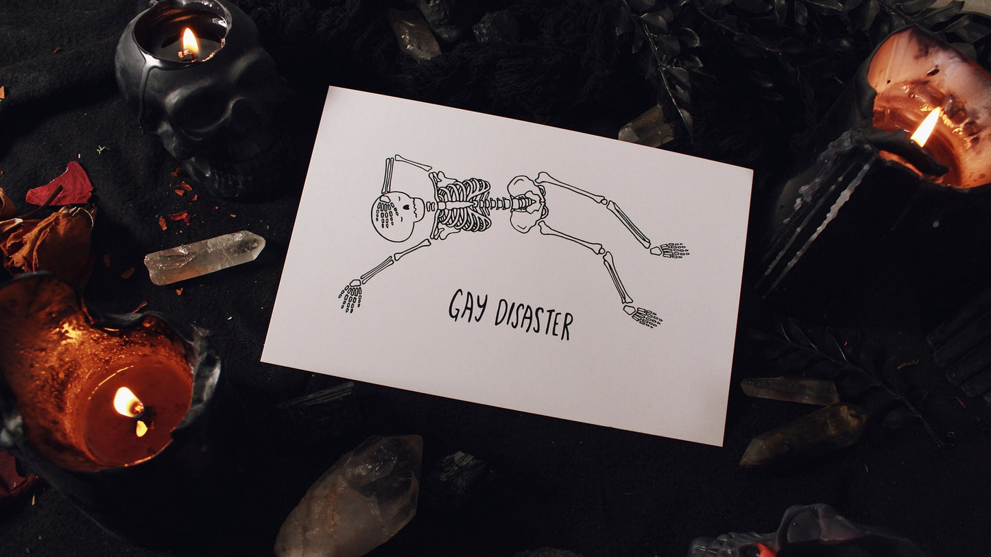 Gay Disaster Print - Illustration of a skeleton laying horizontally with one hand over their forehead and another hand splayed out on the side, on a white background with the words "Gay Disaster" at the bottom. Printed on 8.5" x 5.5" card stock. Original design by GRRRL Spells. 